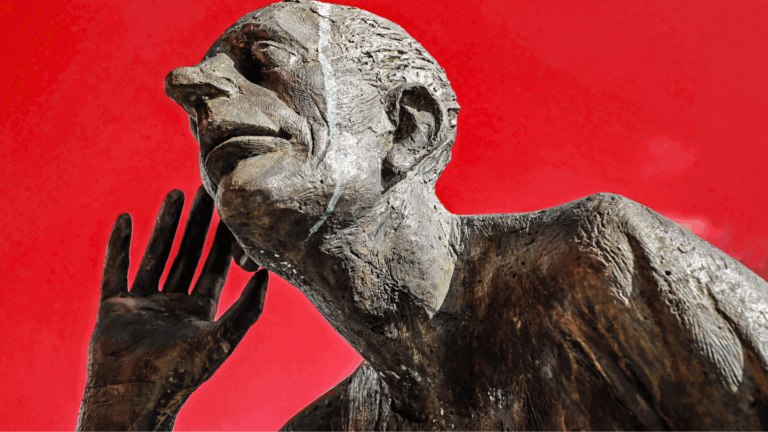 Bronze statue of a man cupping his hand to his ear, against a red background