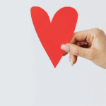 Hand holding a cut out paper heart - 7 traits of engaging content