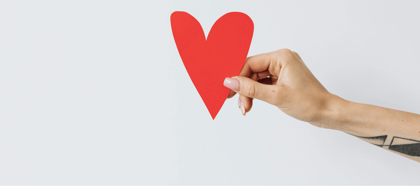 Hand holding a cut out paper heart - 7 traits of engaging content